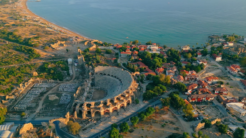 scenic drone shot of the ancient city of Side, Turkey. The largest amphitheater in Turkey. The main street of the ancient city and Mediterranean Sea. High quality 4k footage Royalty-Free Stock Footage #1096275355