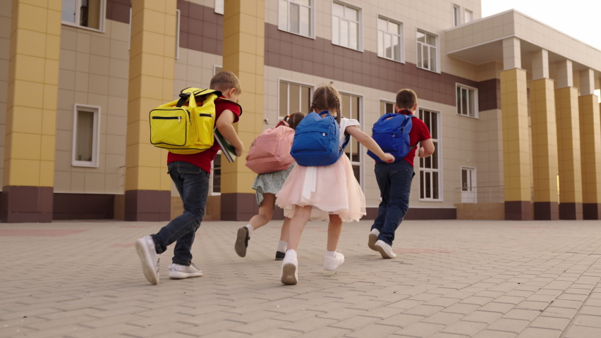 little children run school school yard. view from back. child boy girl running with school backpacks their backs. children education. group children running lesson call. chidhood dream. friendly kid Royalty-Free Stock Footage #1096276343