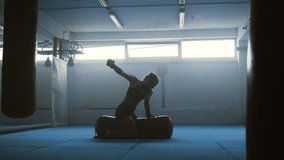 MMA female fighter exercising, training punches, beating punchbag on floor slow motion, wide shot. Young woman in gym, mixed martial arts workout, strong sportsman practicing - Powered by Shutterstock - Get 15% off with code: PIKWIZARD15