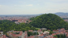 Inscription on video. Graz, Austria. The historic city center aerial view. Mount Schlossberg (Castle Hill). Arises from blue water, Aerial View