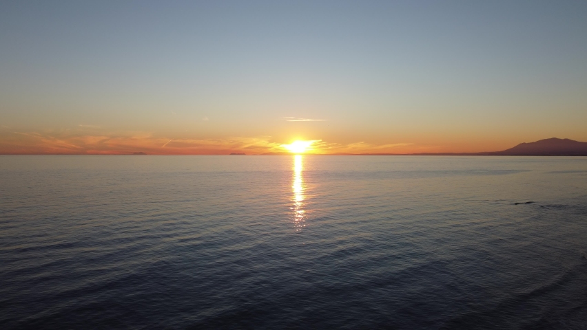 Sunset over Cabopino beach in Marbella, gentle waves.