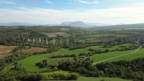 Panoramic view from a drone on passenger train crossing the railway flyover. Overlooking the surrounding mountains in southern France