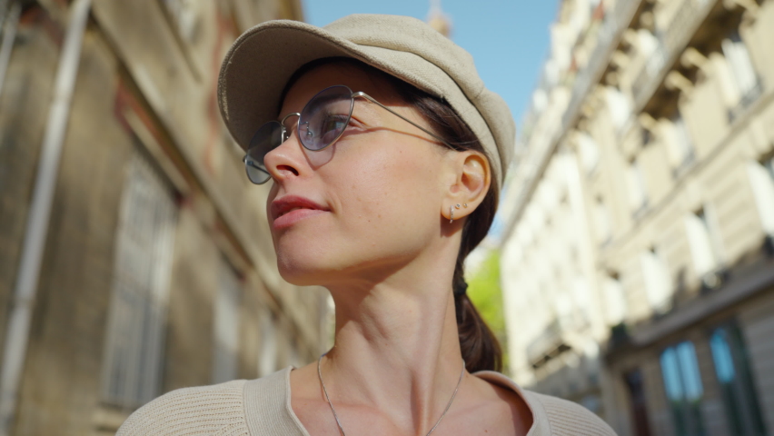 Young tourist looking back at the Eiffel Tower while standing on a famous street