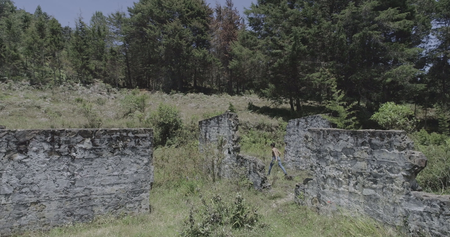 A Young Woman Walks among the Ruins of an Ancient Antenna Structure in the Middle of a Wetland by a Forest near Medellin, Antioquia Colombia - Shot in D-Log