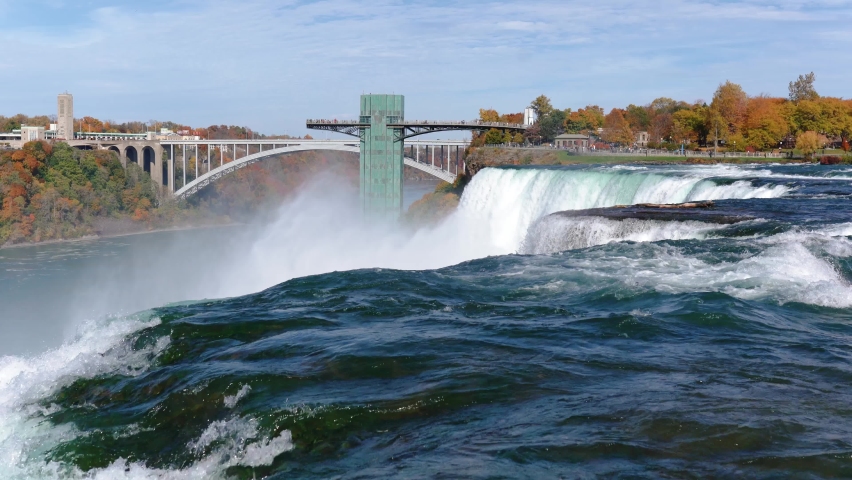 Niagara Falls from the American and Canadian sides. Rainbow over the waterfall. The most popular tourist place. Stormy river that flows into the lake.