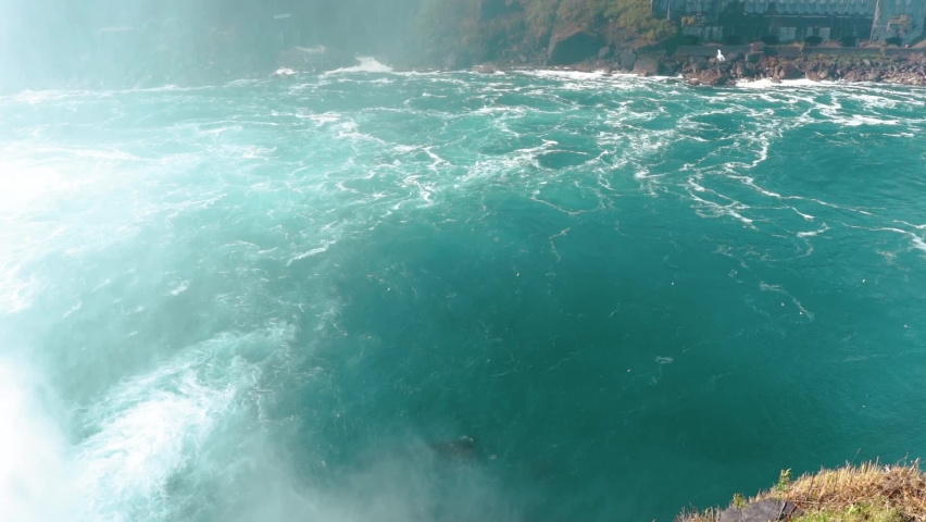 Niagara Falls from the American and Canadian sides. Rainbow over the waterfall. The most popular tourist place. Stormy river that flows into the lake.