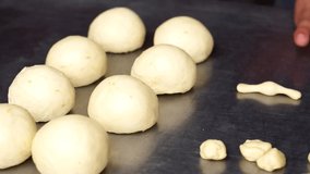Horizontal video of a man's hands preparing dough for pan de muerto.