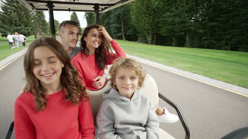 Family with children riding a golf cart on vacation. Parents, son and daughter ride together in a car and look around. High quality 4k footage. 3D Illustration