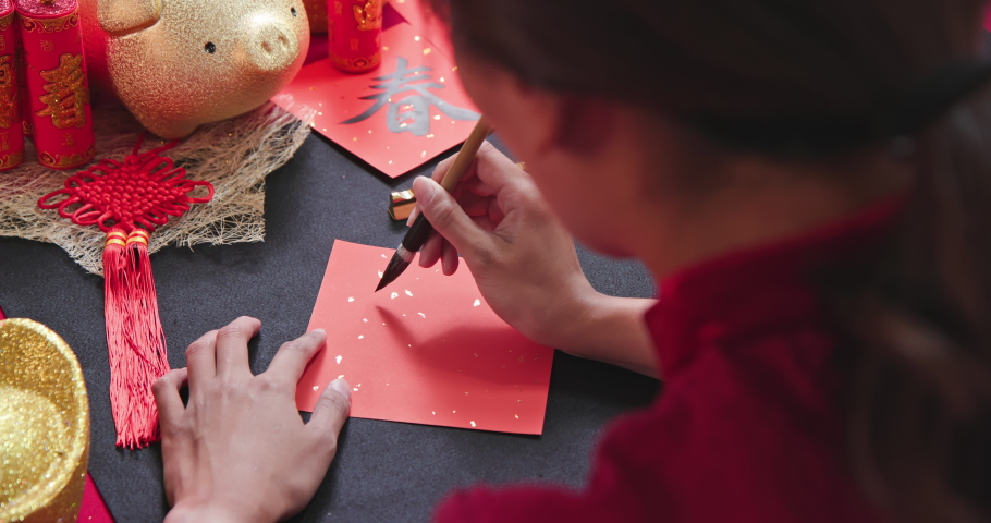 back view video of asian woman write spring festival couplet to celebrate Chinese new year with word meaning Rabbit
