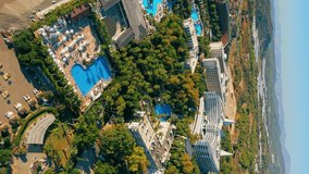 vertical aerial video of a luxury hotel resort, pools and city of Okurcalar, Turkey. High quality 4k footage