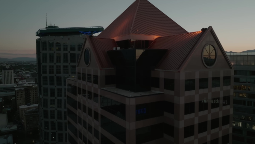 drone shots high building tall buildings at sunset in Salt Lake City Utah cloud day Night time Mountain behind