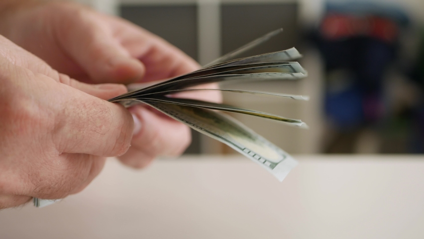 Blurred Shooting with a Man Counting Cash Money, Calculating Salary Payments and Paying in Cash. Financial Investments Concept.