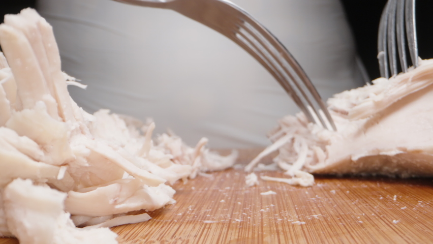 The cook tears off slices of boiled chicken with a fork, extremely close-up. Slider Royalty-Free Stock Footage #1096326977