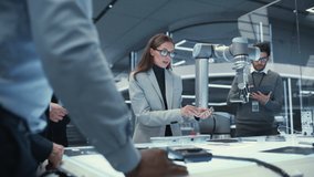 Team Leader Working with Robotics Engineers on a Robot Arm Project, Discussing the Project in Scientific Technology Lab. Young Team Researching and Developing an AI Robotic Arm in Industrial Facility. - Powered by Shutterstock - Get 15% off with code: PIKWIZARD15