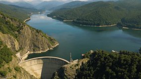 Aerial video of Vidraru dam, in Romania. Footage was shot from a drone from above canyon at Vidraru lake with the dam and the lake in the view and mountains in the background.