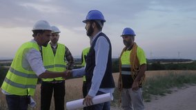 Chief engineer meeting electrical technicians and specialist workers at wind turbine electricity farm - Team of professionals working on green energy project at dawn - Powered by Shutterstock - Get 15% off with code: PIKWIZARD15