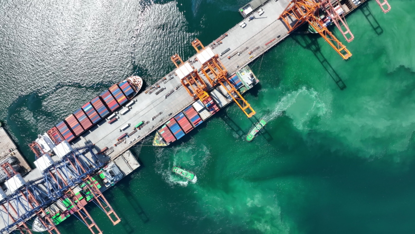 Tug boat drag pull Cargo Container Ship to international Bridge cargo port.  Shipyard Cargo Container Sea Port Freight forwarding service logistics and transportation. Shipping Depot Customs Port. Royalty-Free Stock Footage #1096336981