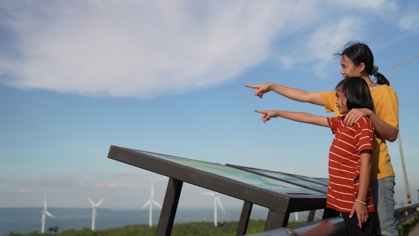 Mother and children read data on board and pointing on blue sky background