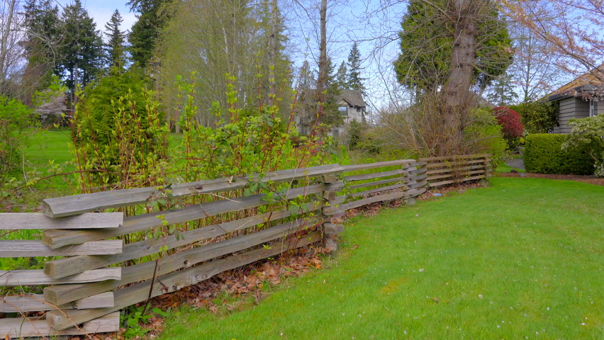 Establishing shot of green and wood fence in Vancouver, Canada, North America. Outdoor landscape. Security and privacy concept. Day time on June 2022. Still camera view. ProRes 422 HQ.