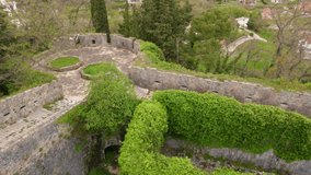 Slowmotion aerial video. A young woman and her son tourists visit the Fortress Spanjola or Spanish fortress in Herceg-Novi. They walk the walls of the fort. Travel to Montenegro