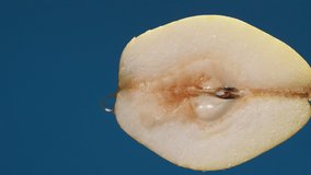 Vertical yellow half pear on a blue dark background with drops of water rolling down the pear and flowing splashing with isolated background - Powered by Shutterstock - Get 15% off with code: PIKWIZARD15