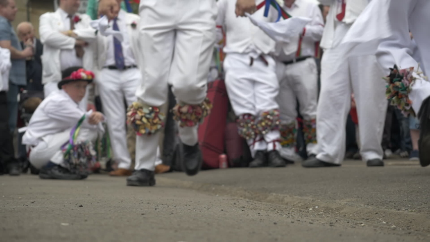 Morris dancing slow motion feet on pavement with crowd watching