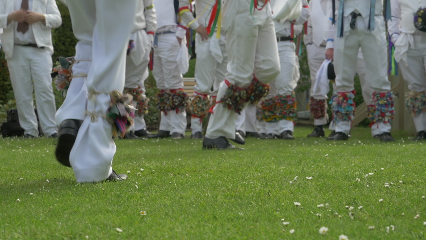 Morris dancers legs feet skipping in time, low angle dance moves on grass
