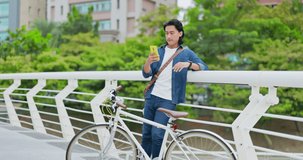 asian man having video call happily beside his bike
