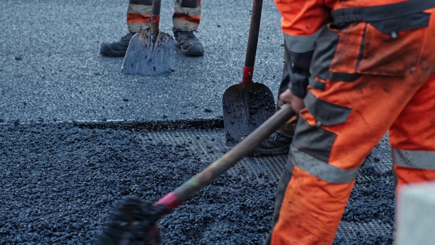 Roadwork Physical Workers in Protective Work Wear Repairing Street Tarmac Surface with Hot Asphalt Royalty-Free Stock Footage #1096371205