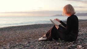 Young woman reading a book by the sea at sunset. Woman relaxing on beach. - Powered by Shutterstock - Get 15% off with code: PIKWIZARD15