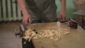 the master sweeps the chips with a brush after processing the wood from the table. slow motion video