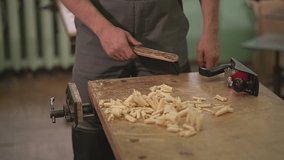 the master sweeps the chips with a brush after processing the wood from the table. live video