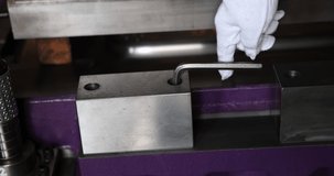 Parts of a press die being fastened with a hexagonal wrench. Slow motion 4K video.