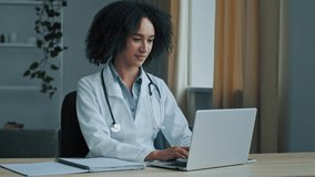 African woman doctor physician student of medical university intern psychotherapist use laptop female therapist nurse consulting patient distantly in online chat type recipe for patient on computer  - Powered by Shutterstock - Get 15% off with code: PIKWIZARD15