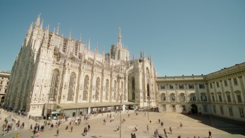 Tourists walk near ancient Duomo church in center of Milan