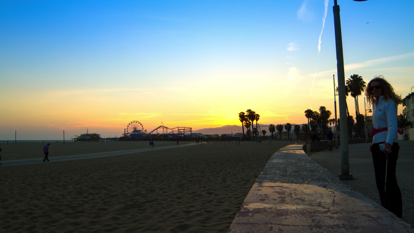 Time Lapse Shot Of People At Beach With Famous Amusement Park During Sunset - Santa Monica, California
