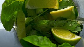 Closeup preparing organic vegetable smoothie from sliced cucumber kale avocado lime celery parsley in super slow motion top view. Mixing fresh raw ingredients for vitamin cocktail in electric blender. - Powered by Shutterstock - Get 15% off with code: PIKWIZARD15