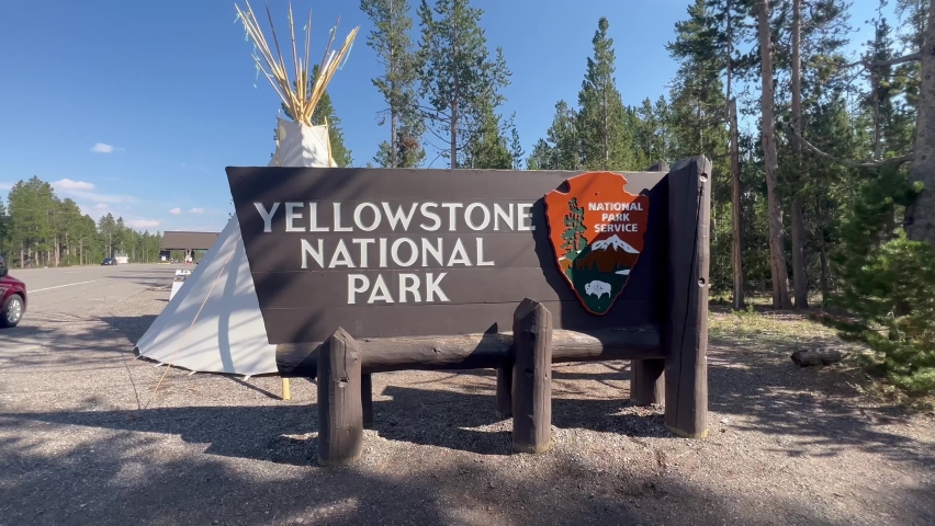 Yellowstone National Park Main Entrance Sign with a Teepee in back of it for the 150th anniversary