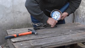 The video shows how a worker holds a grinder tool in his hands. He loosens the nut with a wrench, unscrews it with his hands and removes the cutting wheel.