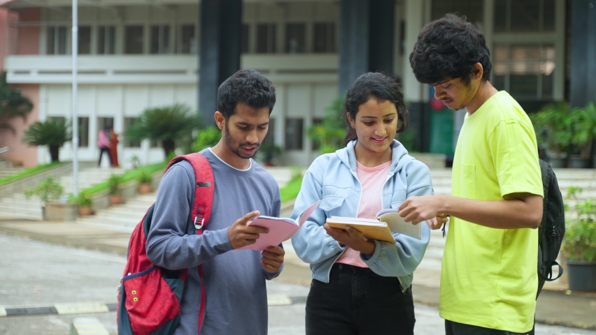 group of Students busy discussing about syllabus at college campus from book - concept of intelligence, learning and togetherness. Royalty-Free Stock Footage #1096415219