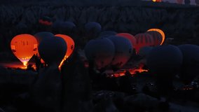 numerous and colorful air balloons with lots of people preparing to fly over gorgeous Cappadocia in the early morning. High quality 4k footage