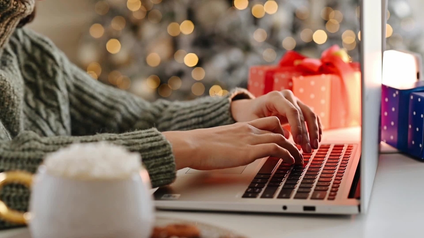 Christmas online communication on the Internet, online shopping, sales and discounts during the winter holidays. Female hands on laptop typing with blurred bokeh lights Royalty-Free Stock Footage #1096440837