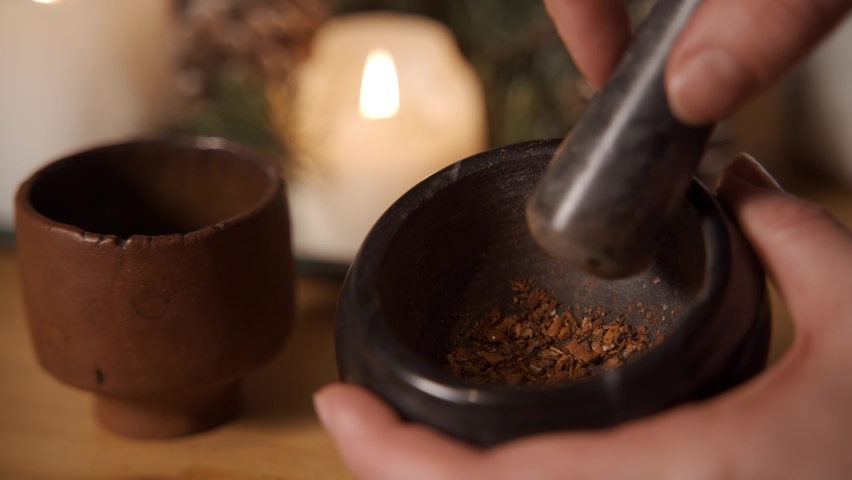 Chinese traditional medicine with herb and spices and doctor is pulping the herb by using a ceramic bowl , front view for advertising