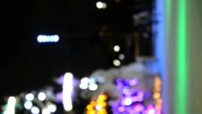 Blurred background. Many people skating on an open-air ice rink, decorated with large Christmas New Year tree, on winter night. New Year Christmas holidays celebrate. Holidays backdrop. Vertical video