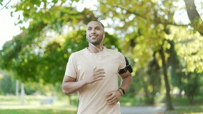 young handsome sporty guy runner, morning run in the city urban park Running outdoors healthy active sport lifestyle. fitness man jogging. listens to music or a podcast in headphones - Powered by Shutterstock - Get 15% off with code: PIKWIZARD15