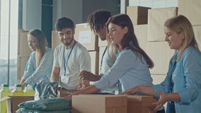 The Concept of Social Aid: Cute Young Boy Help to Volunteers to Sorting Humanitarian Aid at Distribution or Refugee Assistance Center. Charity, Donation, and Volunteering Concept.Volunteer Warehouse - Powered by Shutterstock - Get 15% off with code: PIKWIZARD15