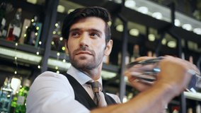 Professional man bartender shaking cocktail drink in cocktail shaker serving customer on counter at luxury restaurant bar. Barman preparing mixed alcoholic drink celebrating holiday party at nightclub - Powered by Shutterstock - Get 15% off with code: PIKWIZARD15