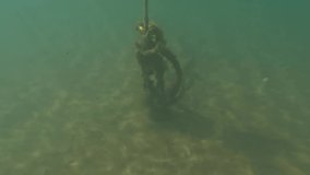Half underwater tilt up view of isolated yellow floating buoy on sea water. Slow motion