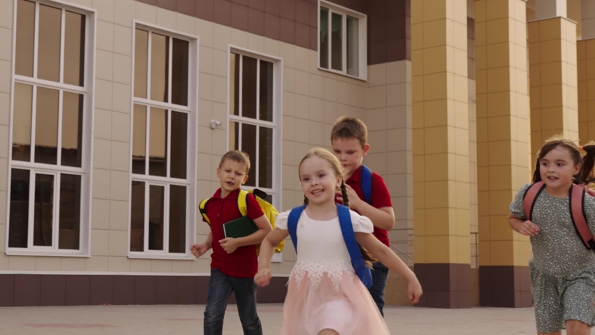 happy little children with school backpacks run lesson. cheerful friendly class child. girls boys laugh run with their school bags backs. cheerful happy childhood. school game catch-up. call to class Royalty-Free Stock Footage #1096468539