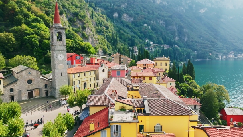 Aerial shot of old town Varenna on the coast of Lake Como. Flying over colorful houses of Varenna village on Lake Como, Italy. Summer luxury tourism landmark romantic honeymoon travel destination